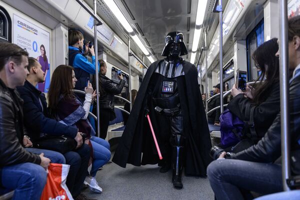 Пассажиры Московского метрополитена фотографируют персонажа фантастического фильма Звездные войны Дарта Вейдера в день Звездных войн