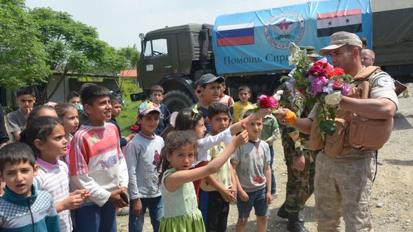 Жители сирийской деревни Брабишбо встречают цветами и апельсинами российских военных, доставивших гуманитарную помощь