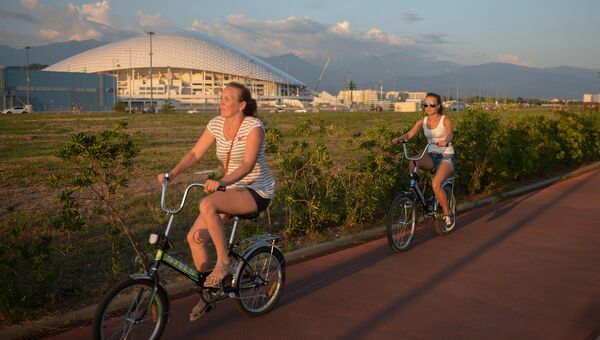 Отдыхающие катаются на велосипедах на набережной в Сочи