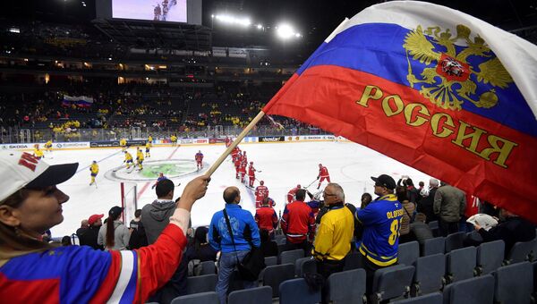 Болельщики следят за хоккейным матчем Россия-Швеция.
