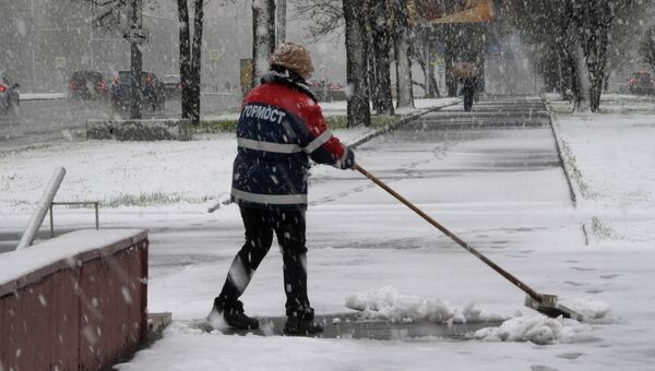 Сотрудница ГБУ Гормост убирает снег на Ленинском проспекте в Москве