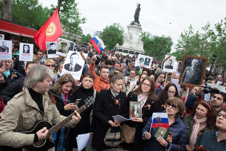 Участники марша Бессмертный полк в Париже, возглавляемого послом России во Франции Александром Орловым, следуют от площади Республики на кладбище Пер-Лашез для возложения цветов к могиле Неизвестного солдата