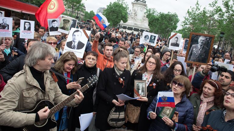 Участники марша Бессмертный полк в Париже, возглавляемого послом России во Франции Александром Орловым, следуют от площади Республики на кладбище Пер-Лашез для возложения цветов к могиле Неизвестного солдата