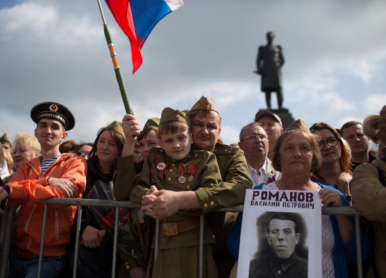 Жители Севастополя во время военного парада в Севастополе, посвященном 72-й годовщине Победы в Великой Отечественной войне и 73-й годовщине освобождения города от немецко-фашистских захватчиков