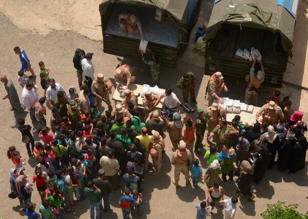 Раздача российской гуманитарной помощи офицерами Центра по примирению враждующих сторон в лагере беженцев Рас-аль-Басит в сирийской провинции Латакия. 3 мая 2017