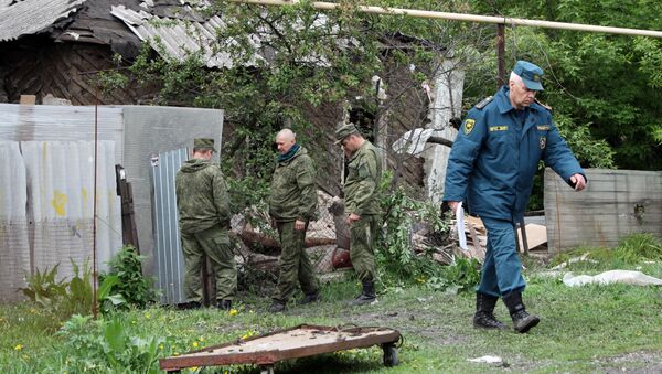 Сотрудники МЧС ДНР осматривают место артиллерийского обстрела Куйбышевского района Донецка