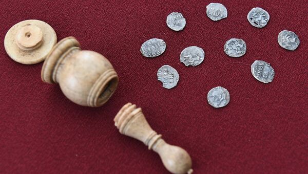 Серебряные монеты и шахматная фигура слона, обнаруженные на улице Пречистенка в Москве