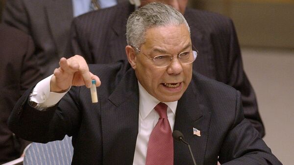 Госсекретарь Колин Пауэлл показывает пробирку, в которой, по его утверждению, находятся образцы иракского оружия массового поражения, на заседании Совета Безопасности ООН. 5 февраля 2003