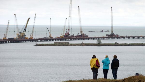 Люди наблюдают за строительством моста в Крыму. Архивное фото