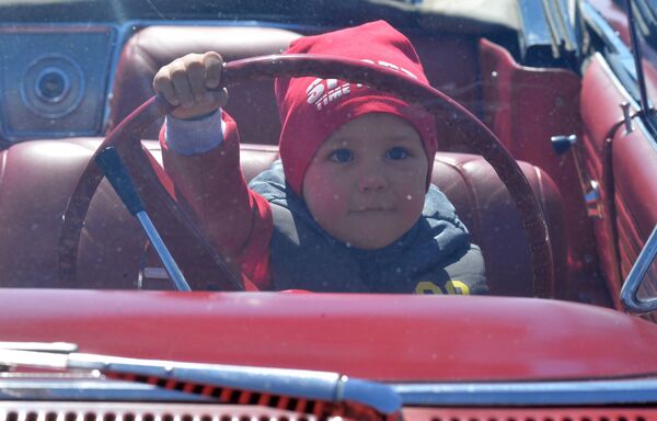Ребенок за рулем автомобиля на международном фестивале Ретро-Минск — 2017 на площади Государственного флага в Минске