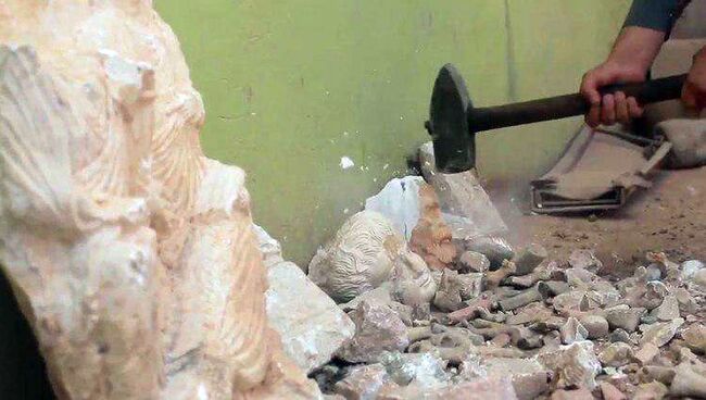 Стоп-кадр видеозаписи, на которой боевики террористической группировки Исламское государство (запрещена на территории РФ) разрушают античные статуи в городе Дура-Европос в Сирии