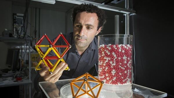 Ученый держит в руках модель кристаллов зерна, открытых его командой