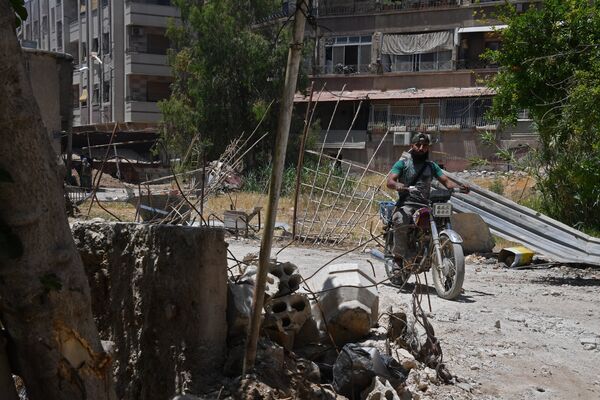 Мужчина на мотоцикле в квартале Кабун в пригороде Дамаска