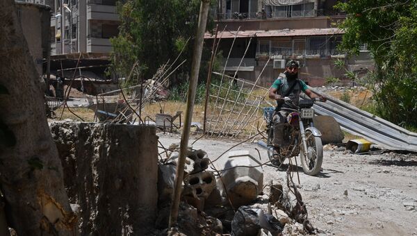 Мужчина на мотоцикле в квартале Кабун в пригороде Дамаска