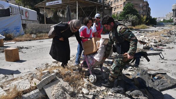 Жители квартала Кабун в пригороде Дамаска во время раздачи гуманитарной помощи. Архивное фото