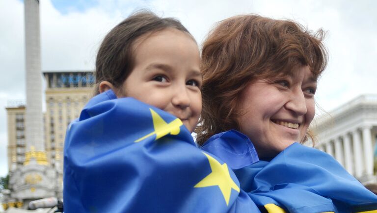 Люди с флагами ЕС и Украины на площади Независимости в Киеве Люди с флагами ЕС и Украины на площади Независимости в Киеве