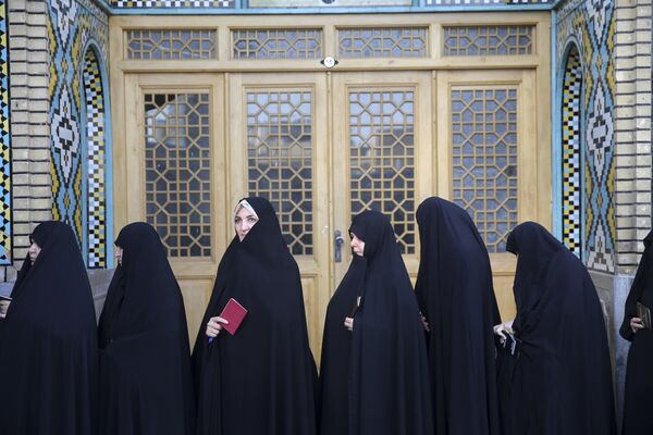Женщины стоят возле избирательного участка в городе Кум, Иран
