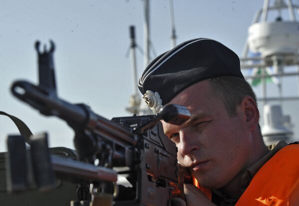 Пограничник проверяет исправность палубного пулемета во время рейда по борьбе с браконьерством осетровых в Каспийском море