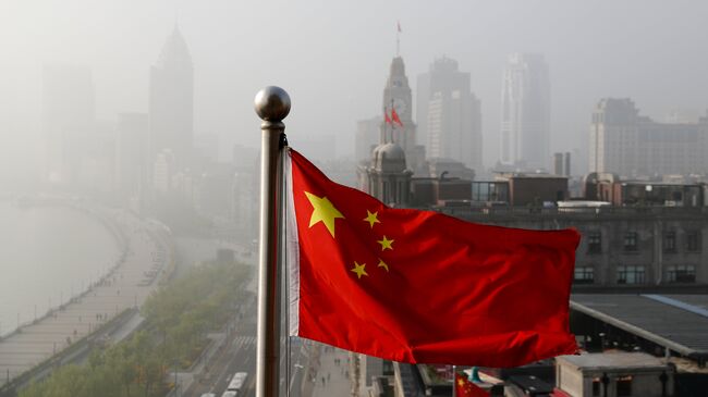 Флаг Китая развевается над офисными зданиями в Шанхае