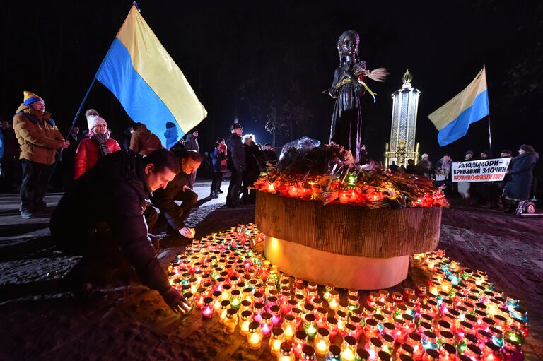 Участники всеукраинской акции Зажги свечу ставят символические лампады к мемориалу памяти жертв голодомора 1932-1933 годов в Киеве