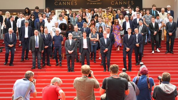 Актеры, режиссеры и организаторы Каннского кинофестиваля на ступенях Дворца фестивалей во время минуты молчания в память о жертвах теракта в Манчестере. 23 мая 2017