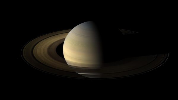Сатурн, наполовину подсвеченный Солнцем в день солнцестояния. архивное фото