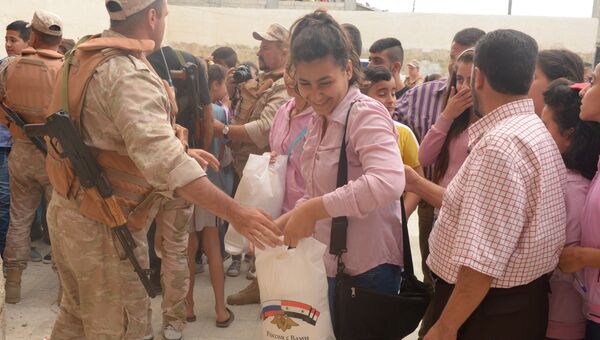 Офицеры российского Центра по примирению враждующих сторон в Сирии раздают гуманитарную помощь жителям деревни Мшейрфа провинции Латакия. Архивное фото