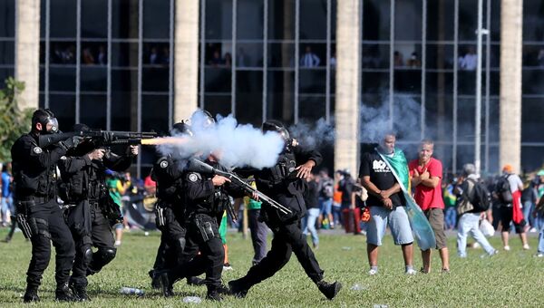 Сотрудники ОМОН сталкиваются с демонстрантами во время акции протеста в Бразилии, 24 мая 2017