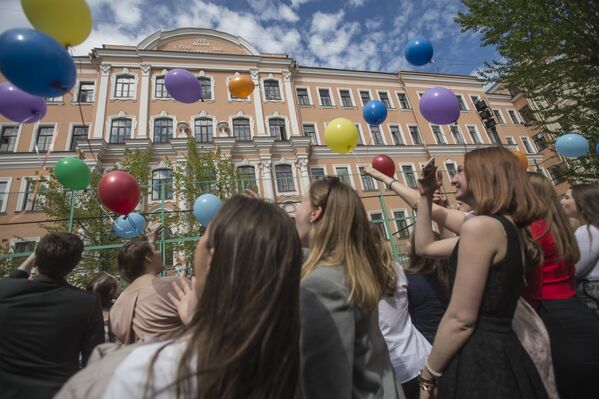 Выпускники запускают воздушные шары во время празднования последнего звонка в средней школе № 222 Петришуле в Санкт-Петербурге