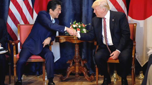 Президент США Трамп и премьер-министр Японии Абэ обменялись рукопожатиями во время двусторонней встречи на саммите G7. Италия, 26 мая 2016
