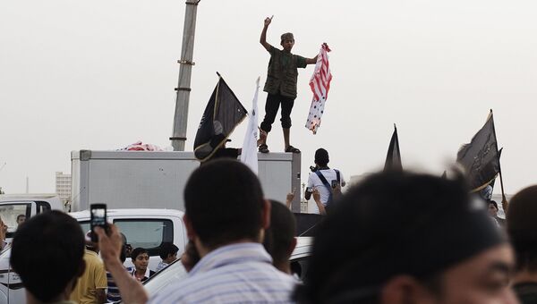 Сторонники и члены террористической группировки Ансар аш-Шариа сжигают флаг США в Бенгази, Ливия. Архивное фото