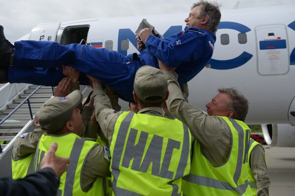 Сотрудники Иркутского авиационного завода качают на руках тест-пилота после успешного первого полета нового российского пассажирского самолета МС-21