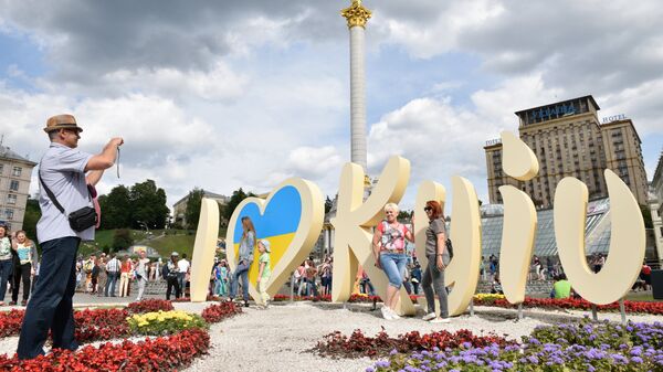 Люди фотографируются у инсталляции в Киеве во время празднования Дня города