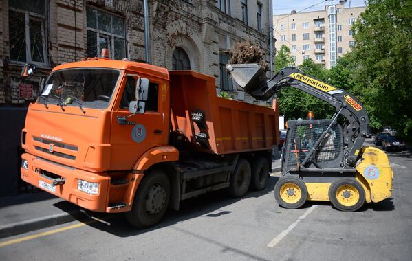Работники коммунальных служб убирают поваленные деревья на одной из улиц Москвы
