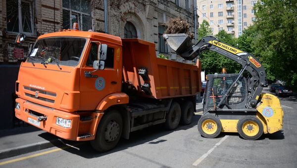 Работники коммунальных служб убирают поваленные деревья на одной из улиц Москвы. Архивное фото