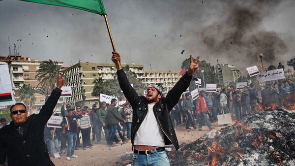Жители Бенгази сжигают портреты Муамара Каддафи, плакаты с его цитатами и Зеленую книгу Каддафи