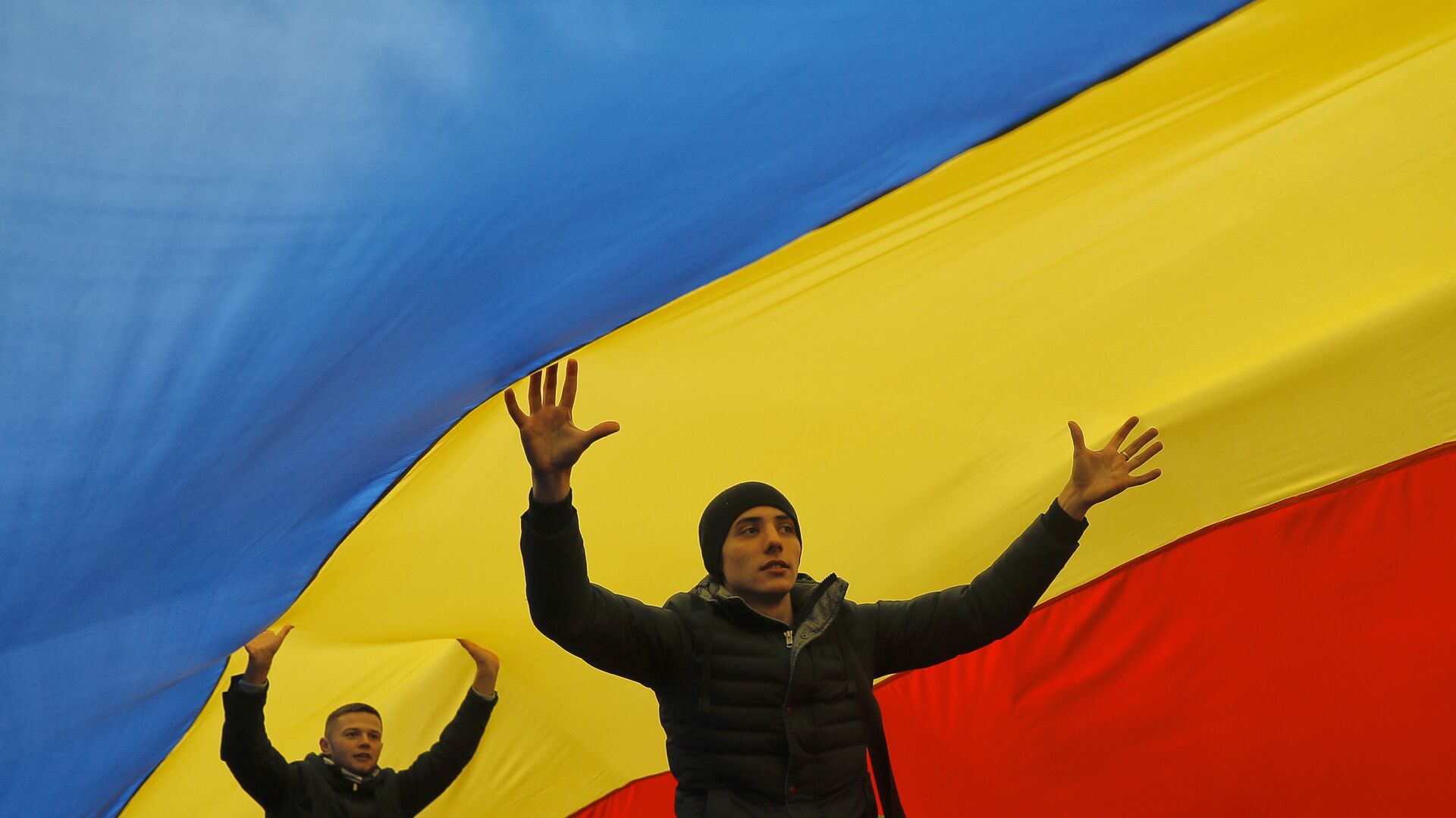 Люди ходят под флагом Молдавии во время акции протеста в Кишиневе 14 ноября 2016 - РИА Новости, 1920, 24.05.2022