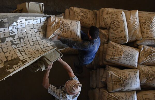 Отгрузка цемента в машину на цементном заводе в пригороде сирийского города Тартуса