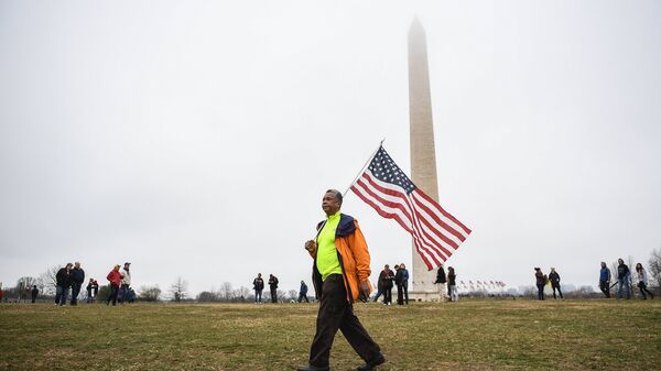 Мужчина с флагом США в Вашингтоне. Архивное фото