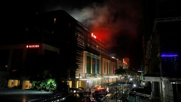 Дым над зданием отеля и казино Resorts World в центре Манилы, Филиппины