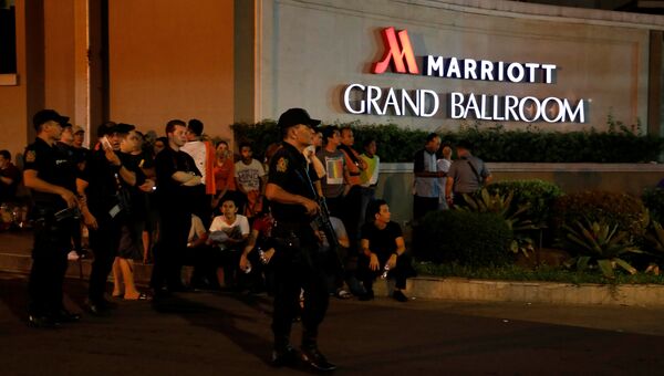 Полицейский и эвакуированные сотрудники отеля и казино в Маниле, Филиппины