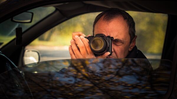 Мужчина фотографирует из окна автомобиля 