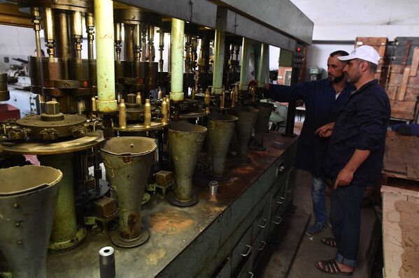 Рабочие в одном из цехов военного завода по изготовлению патронов в пригороде сирийского города Хама