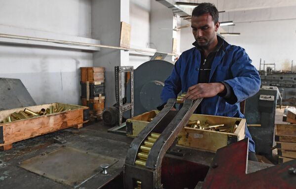 Рабочие в одном из цехов военного завода по изготовлению патронов в пригороде сирийского города Хама