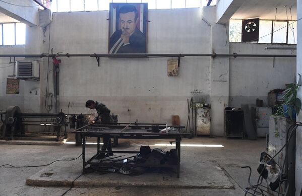 Рабочий в механическом цехе военного завода по изготовлению патронов в пригороде сирийского города Хам