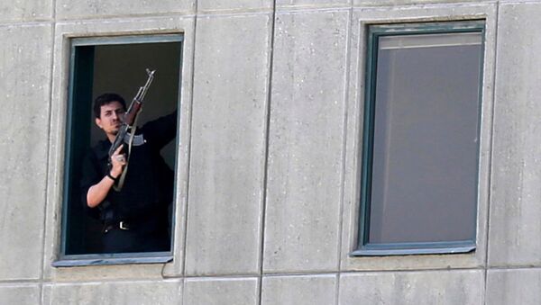 Вооруженный человек в окне здания парламента в Тегеране, Иран. 7 июня 2017