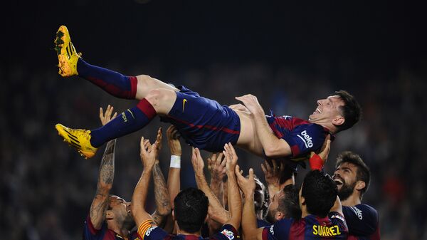 Нападающий футбольного клуба Барселона Лионель Месси с товарищами по команде после победы над Севильей