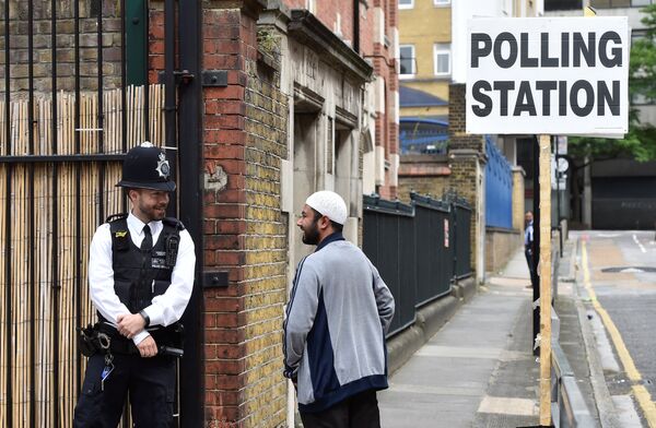 Полицейский возле избирательного участка в Тауэр-Хамлетс, Великобритания. 8 июня 2017