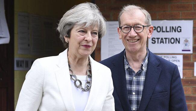 Премьер-министр Великобритании Тереза Мэй и ее супруг Филип Мэй возле участка для голосования на досрочных парламетских выборах в Лондоне. 8 июня 2017