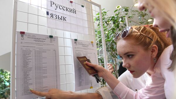 Ученики смотрят списки допущенных к сдаче ЕГЭ по русскому языку. Июнь 2017